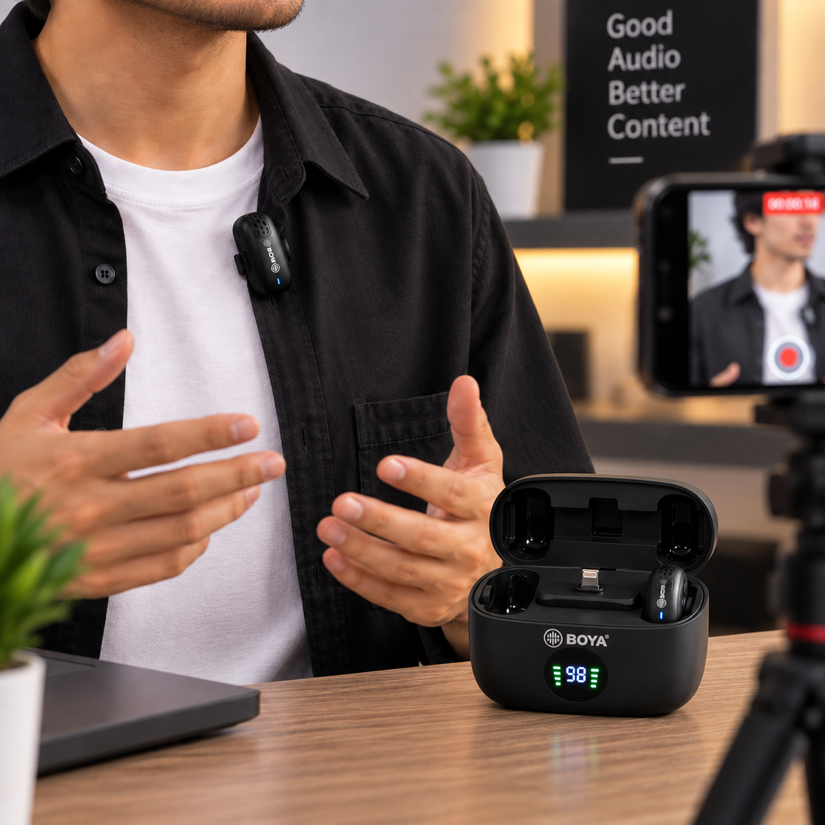 BOYA BY-MW2 wireless microphone clipped to a creator’s shirt with charging case displayed on table